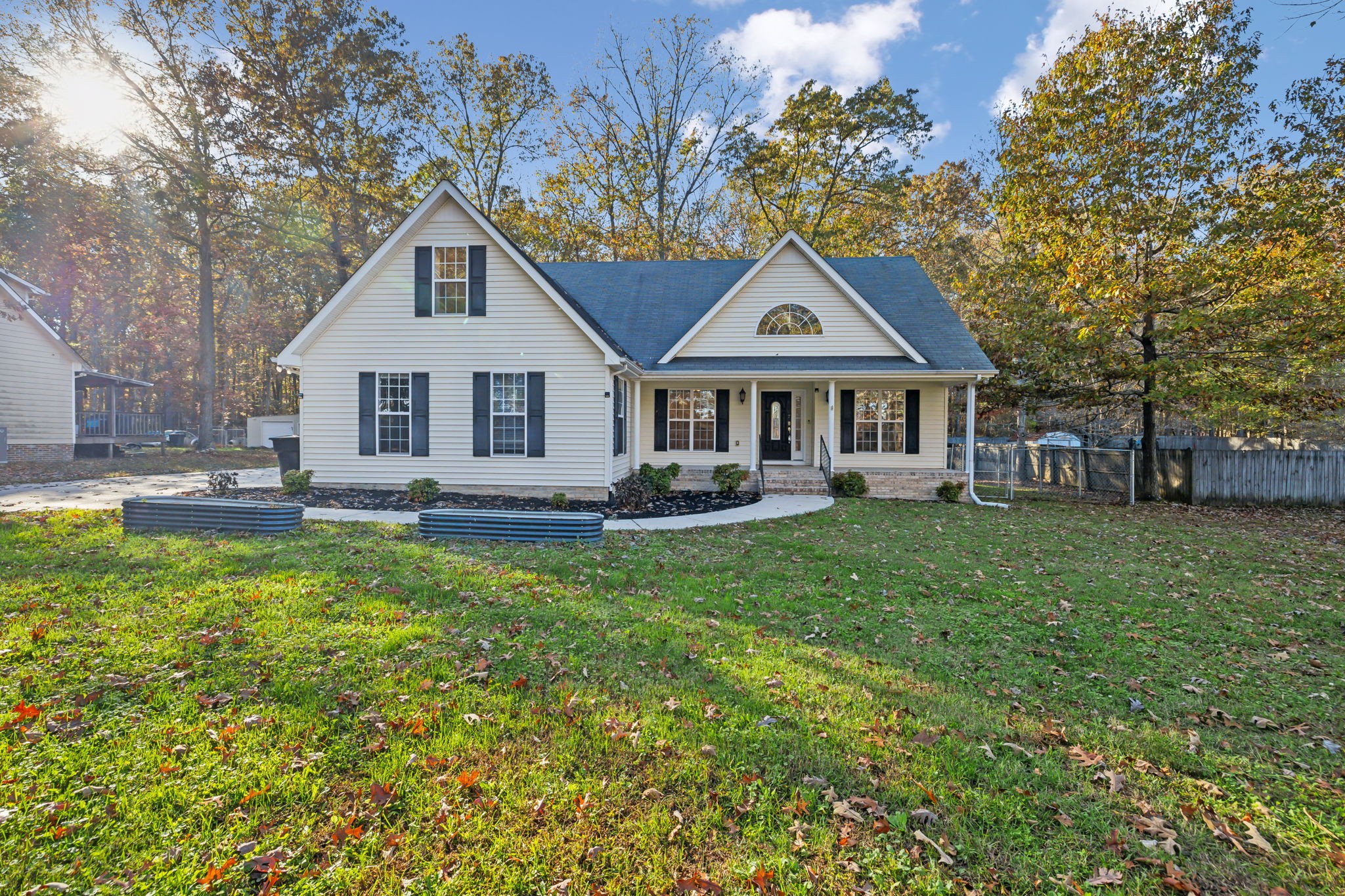 a front view of a house with a garden and trees