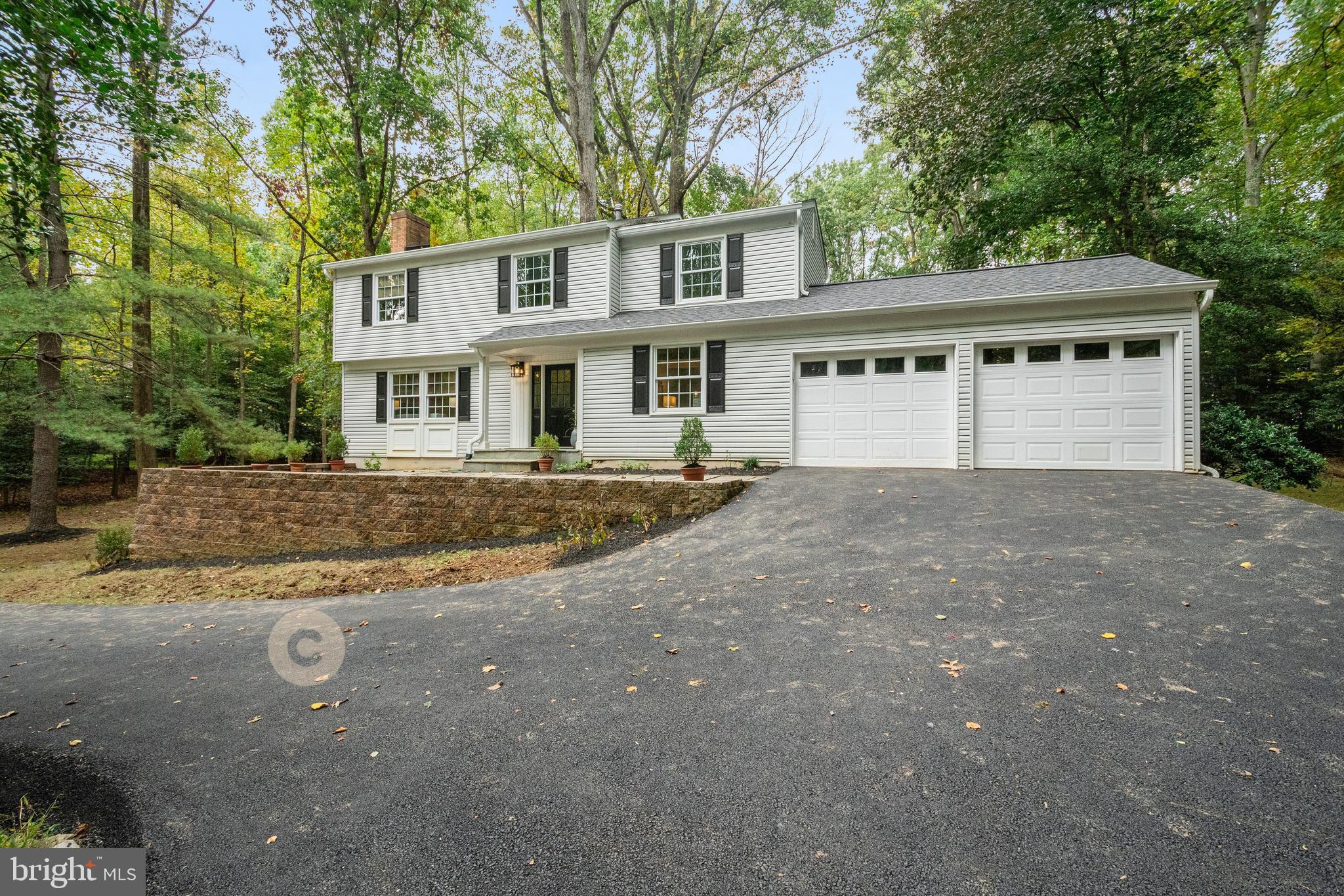 a front view of a house with a yard and trees