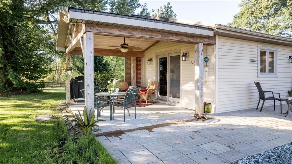 a view of a patio with table and chairs near a yard