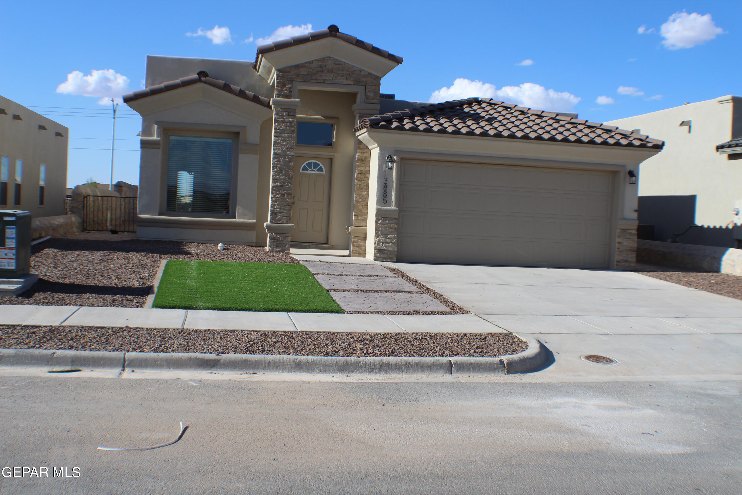 a front view of a house with a garden and a garage