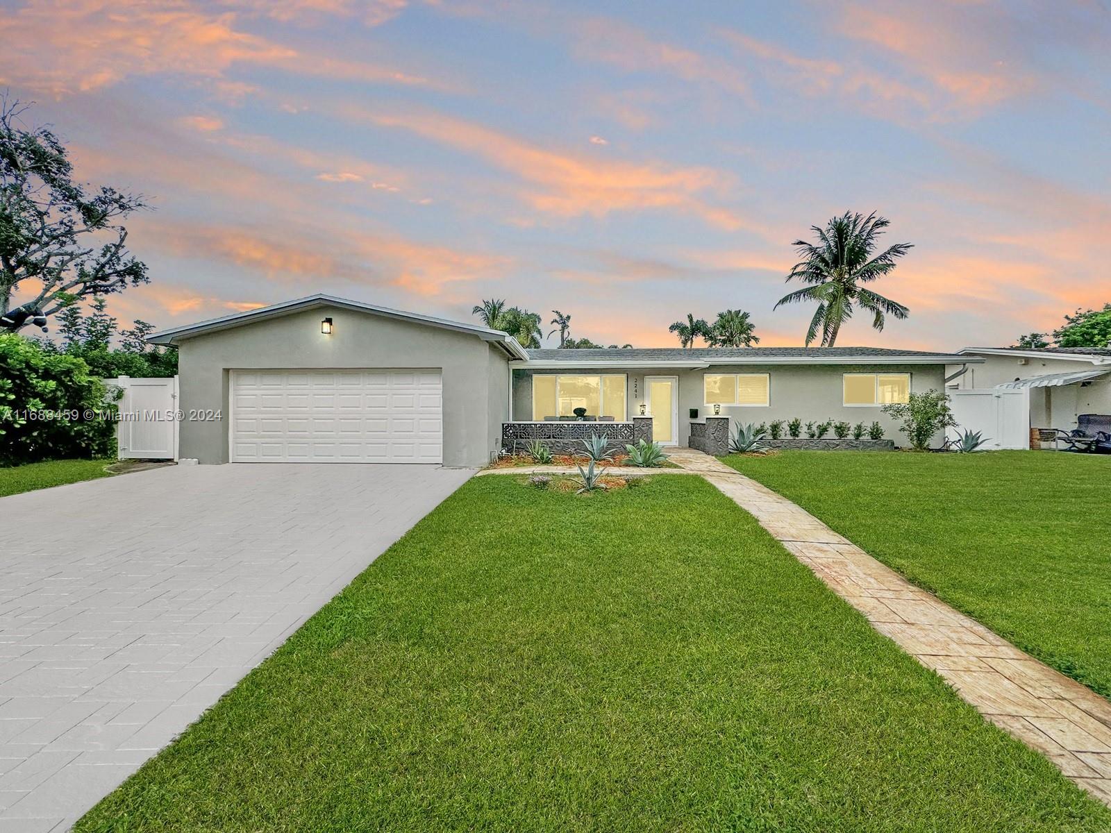 a front view of a house with a yard and lake view