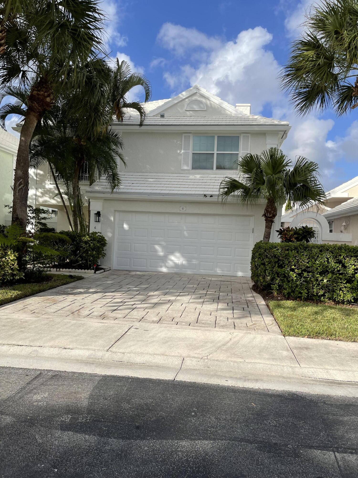 a front view of a house with a yard and a garage