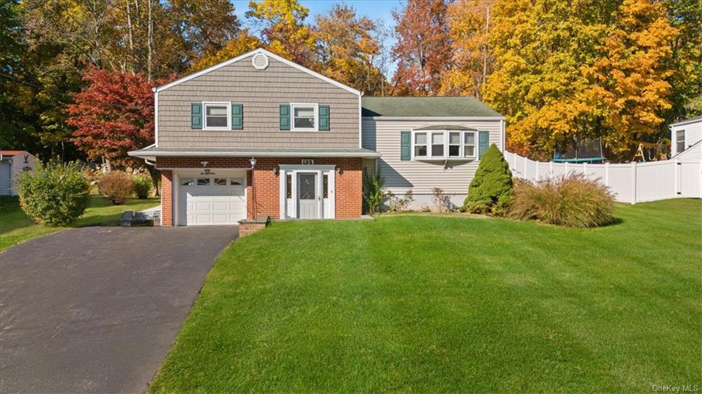 View of front of property featuring a front lawn and a garage