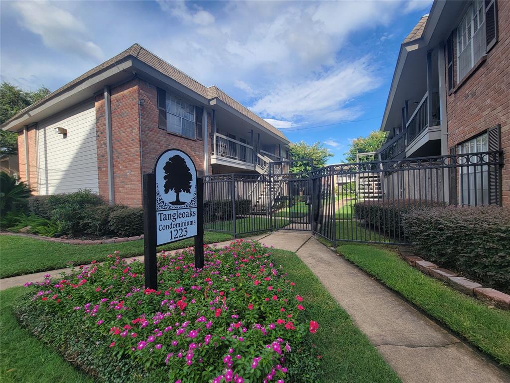 a front view of a house with a yard and flower garden