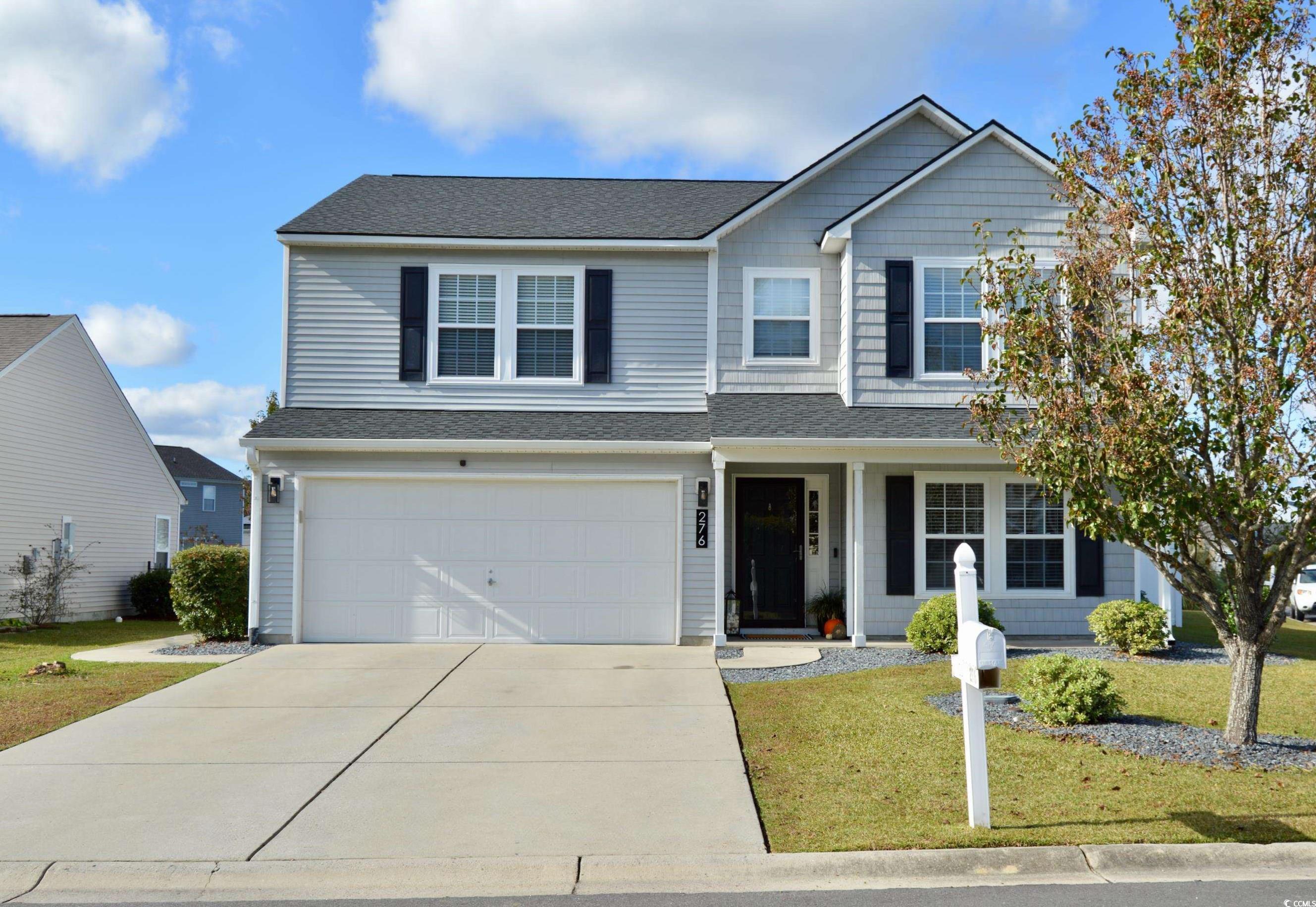 Front of property with a garage and a front yard