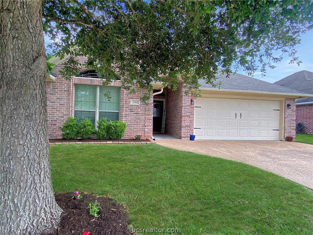 a front view of a house with a garden and yard