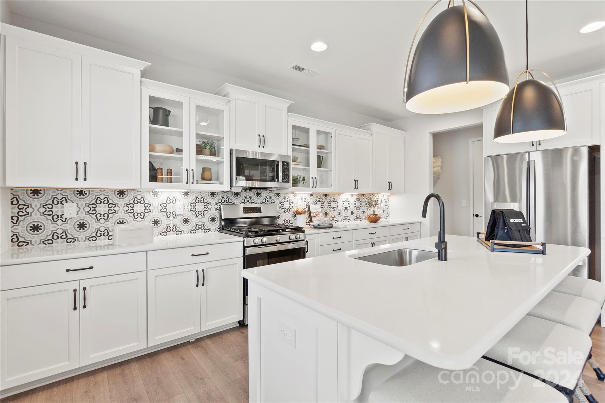 a kitchen with stainless steel appliances a stove a sink a refrigerator and cabinets