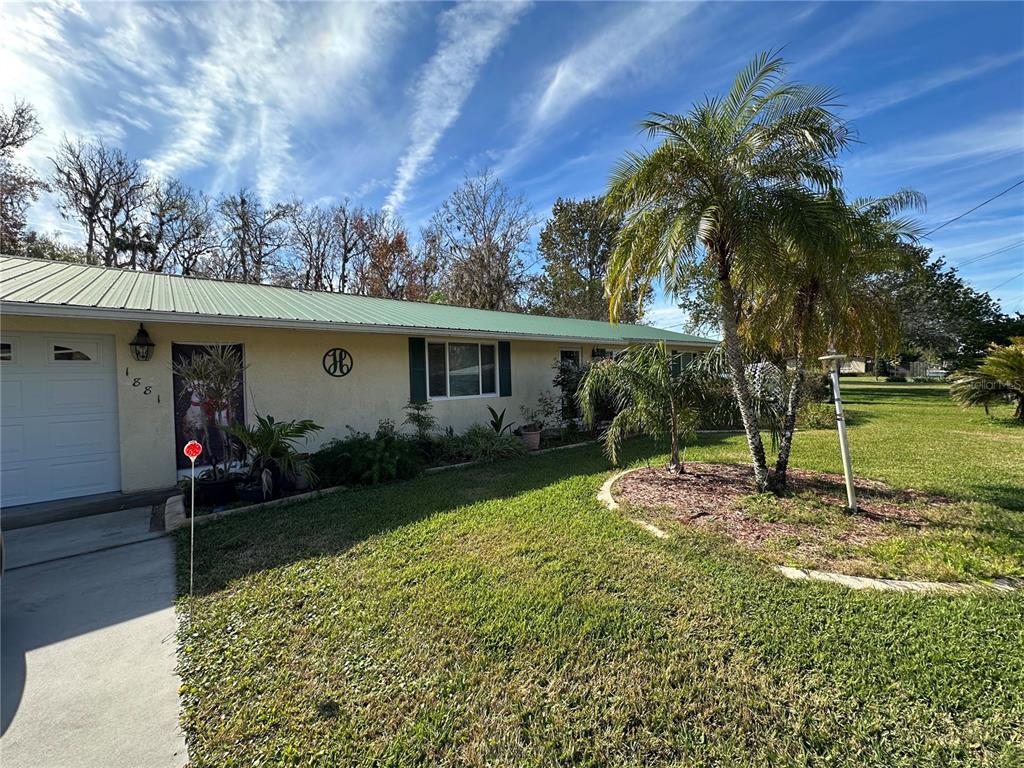 a view of a house with backyard and a tree