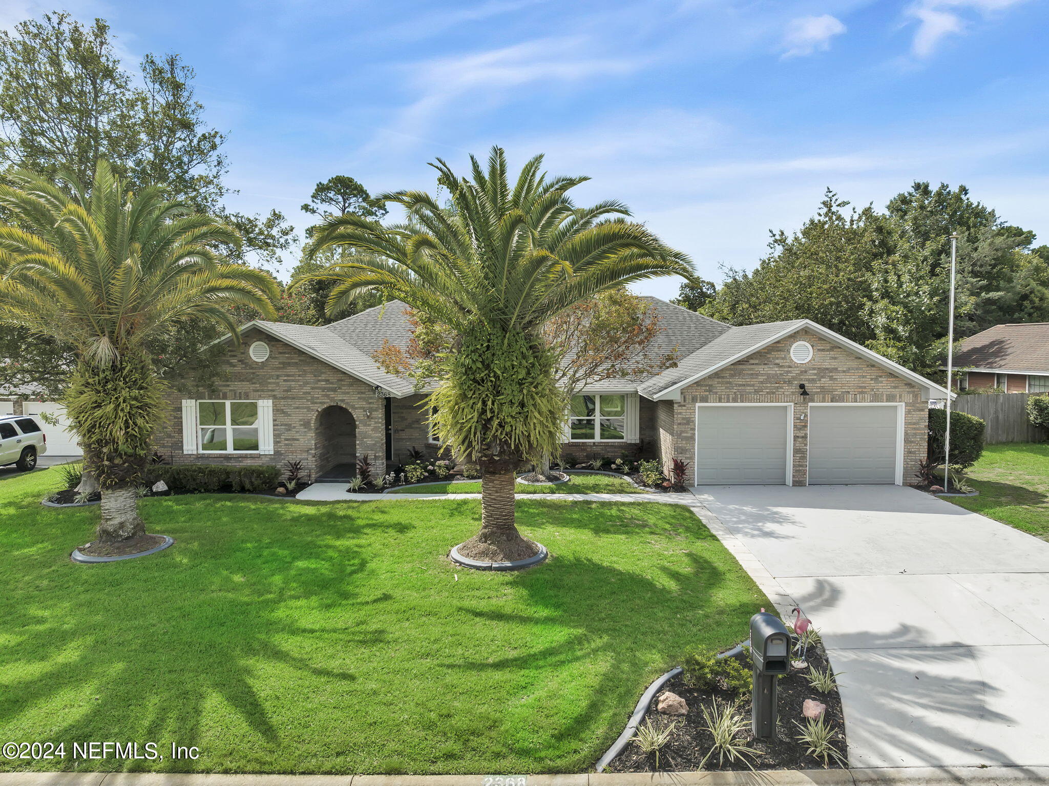 a front view of a house with a yard and trees