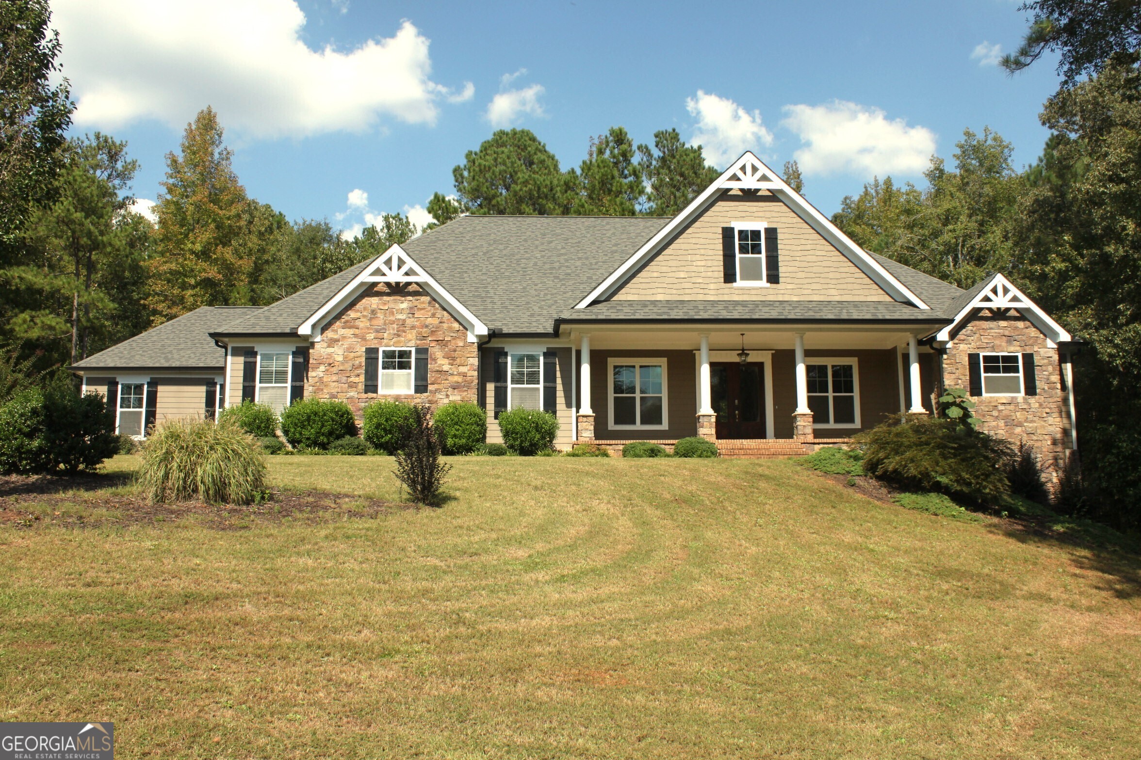 a front view of a house with yard and green space