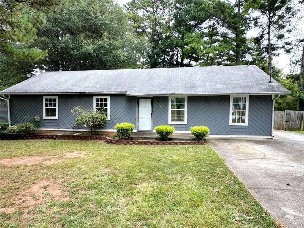 a front view of a house with yard and trees