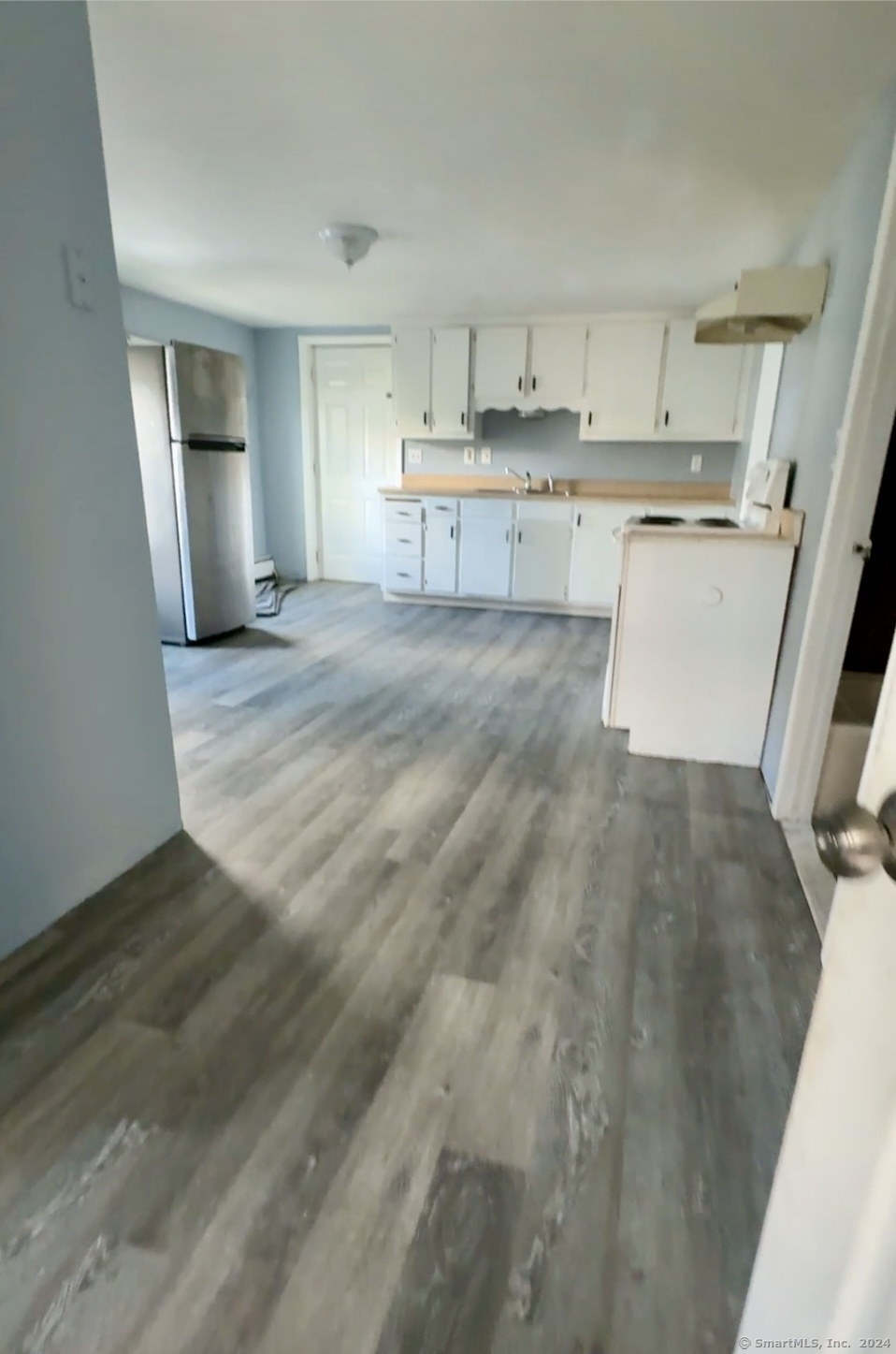 a room with kitchen island a sink stove and refrigerator