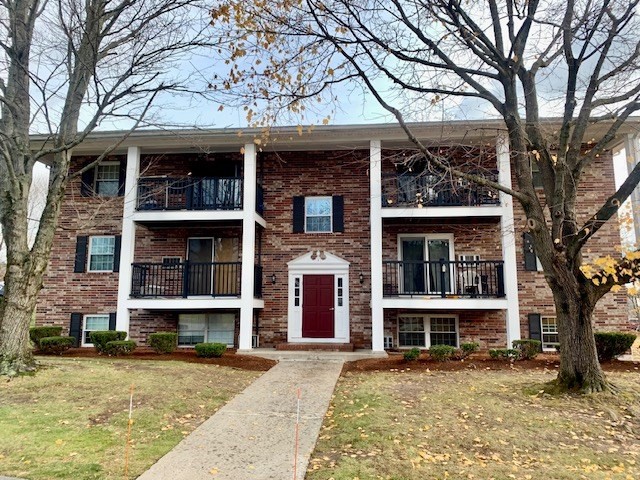 front view of a brick house with a small yard