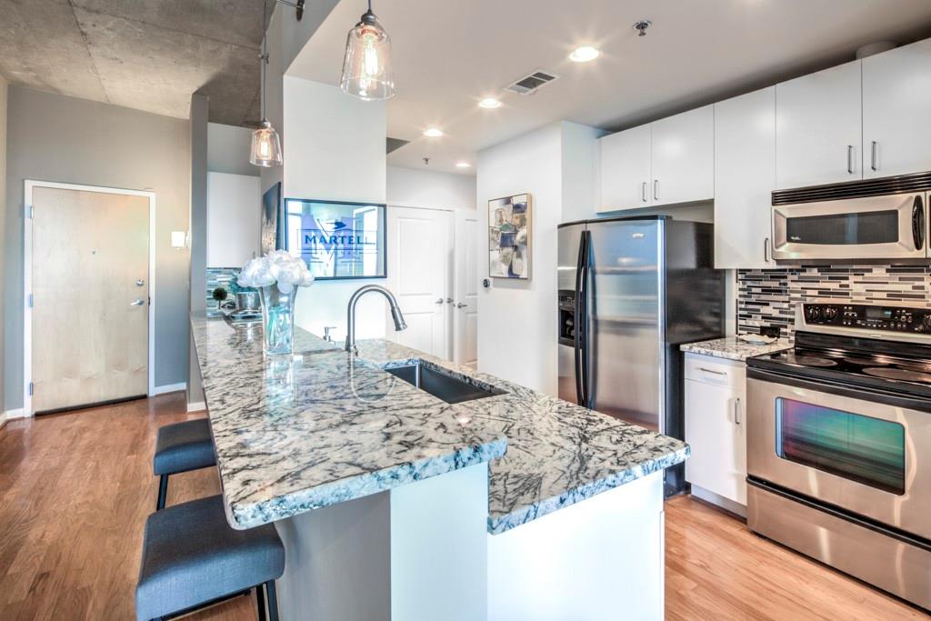 a kitchen with stainless steel appliances granite countertop a stove refrigerator and a microwave