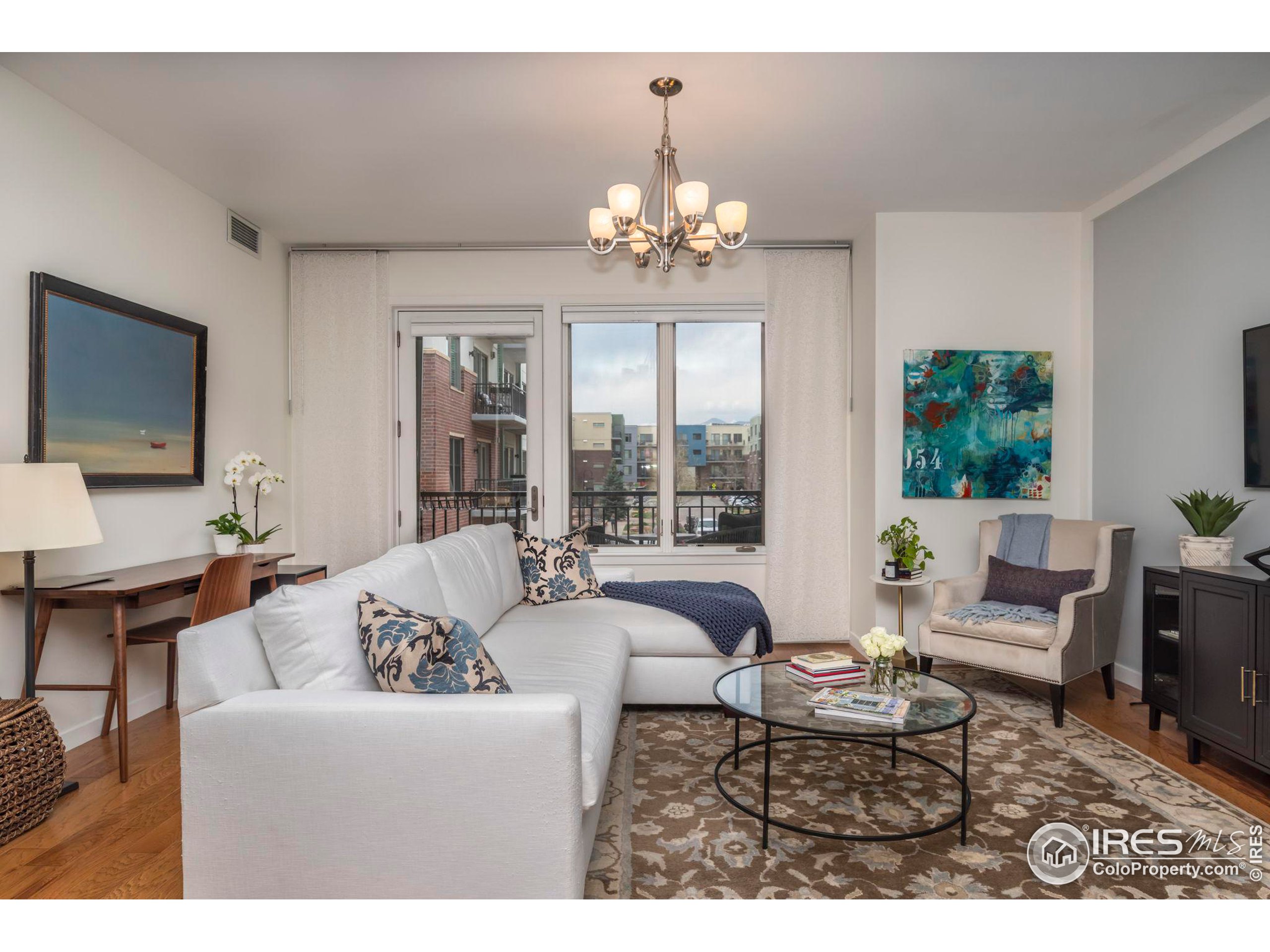 a living room with furniture chandelier and a flat screen tv