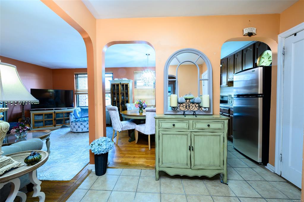 a living room with furniture a flat screen tv and kitchen view