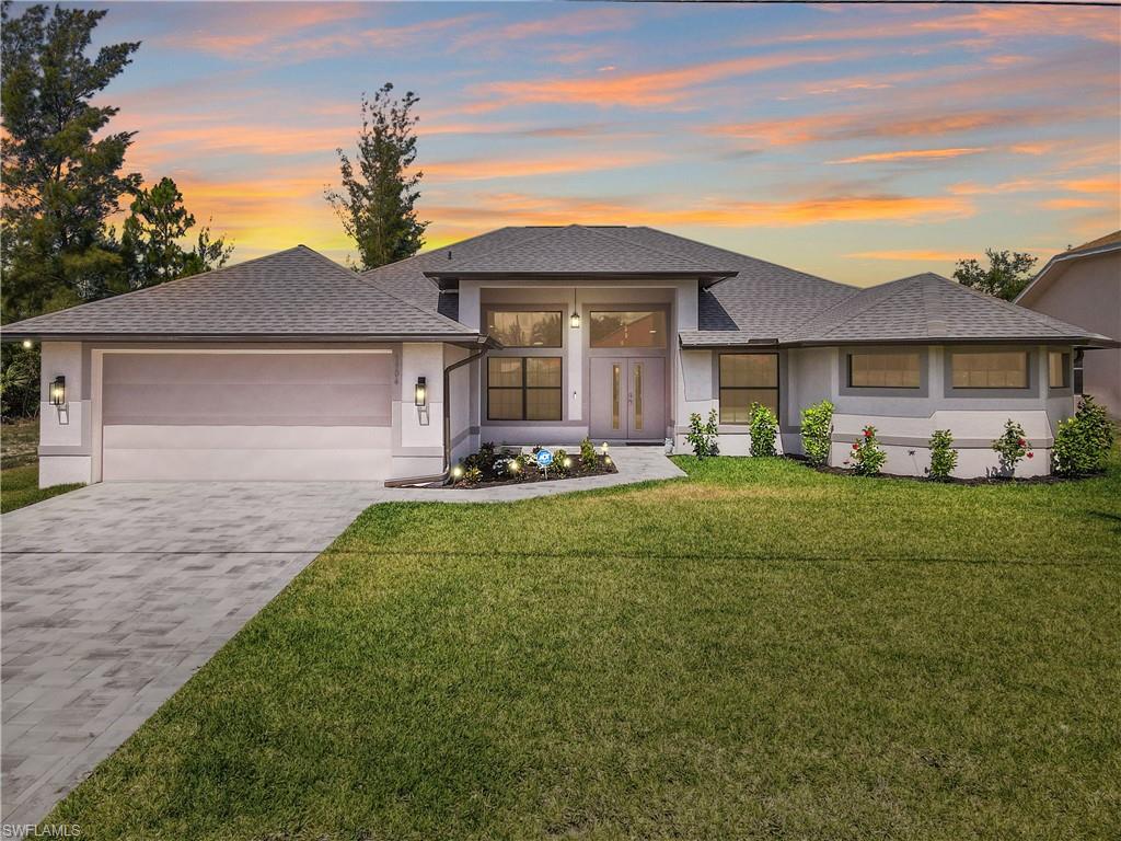 a front view of a house with a yard and garage