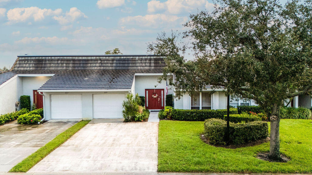 a front view of a house with a yard and trees