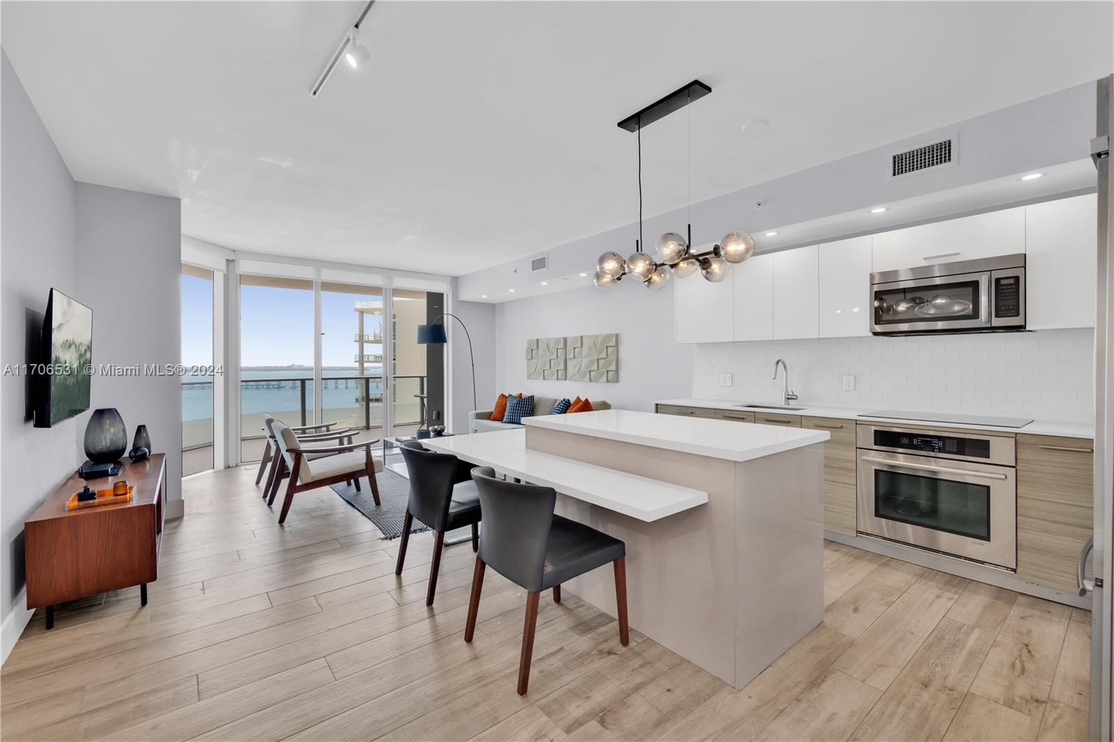 a large kitchen with kitchen island a dining table and chairs