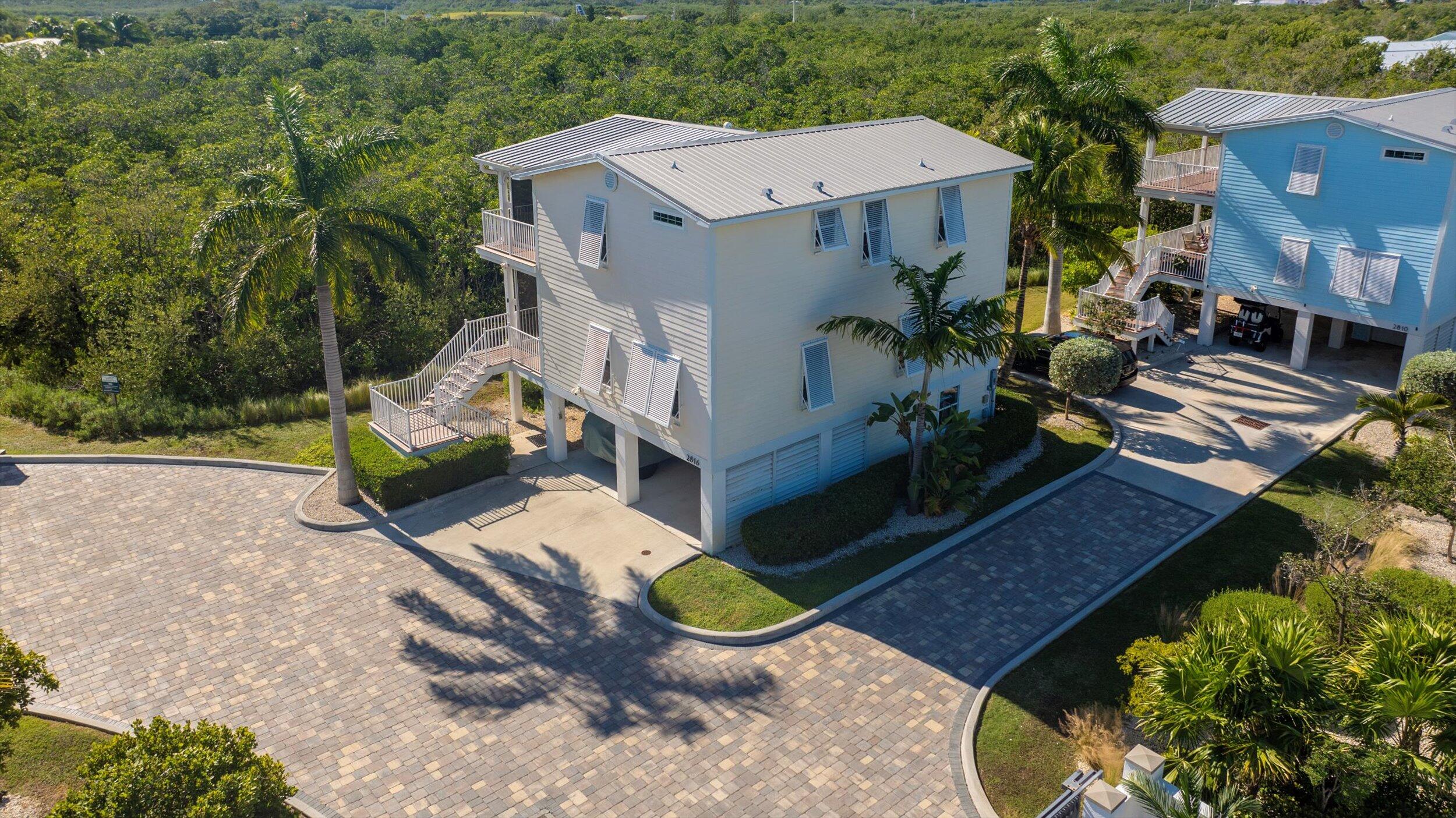 an aerial view of a house with a yard and lake view