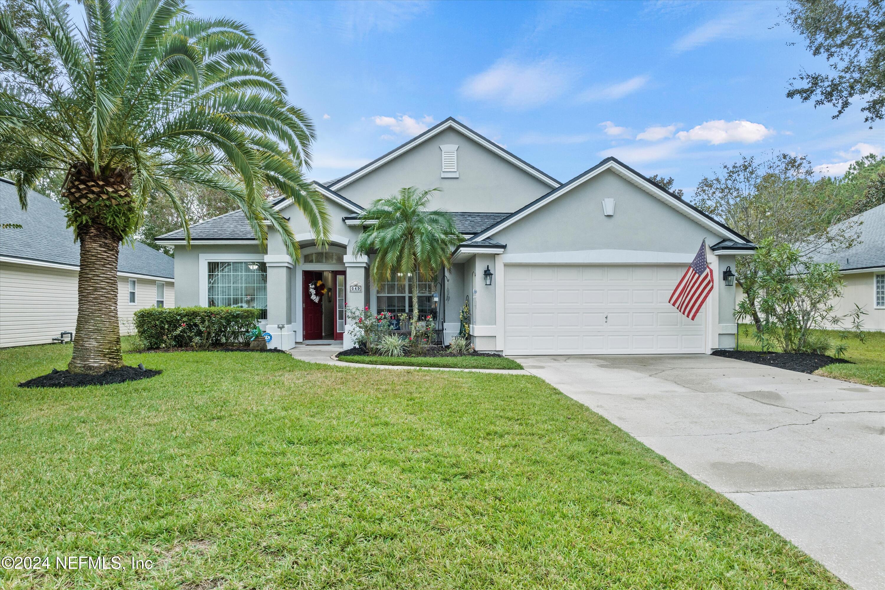 a front view of a house with a yard and garage