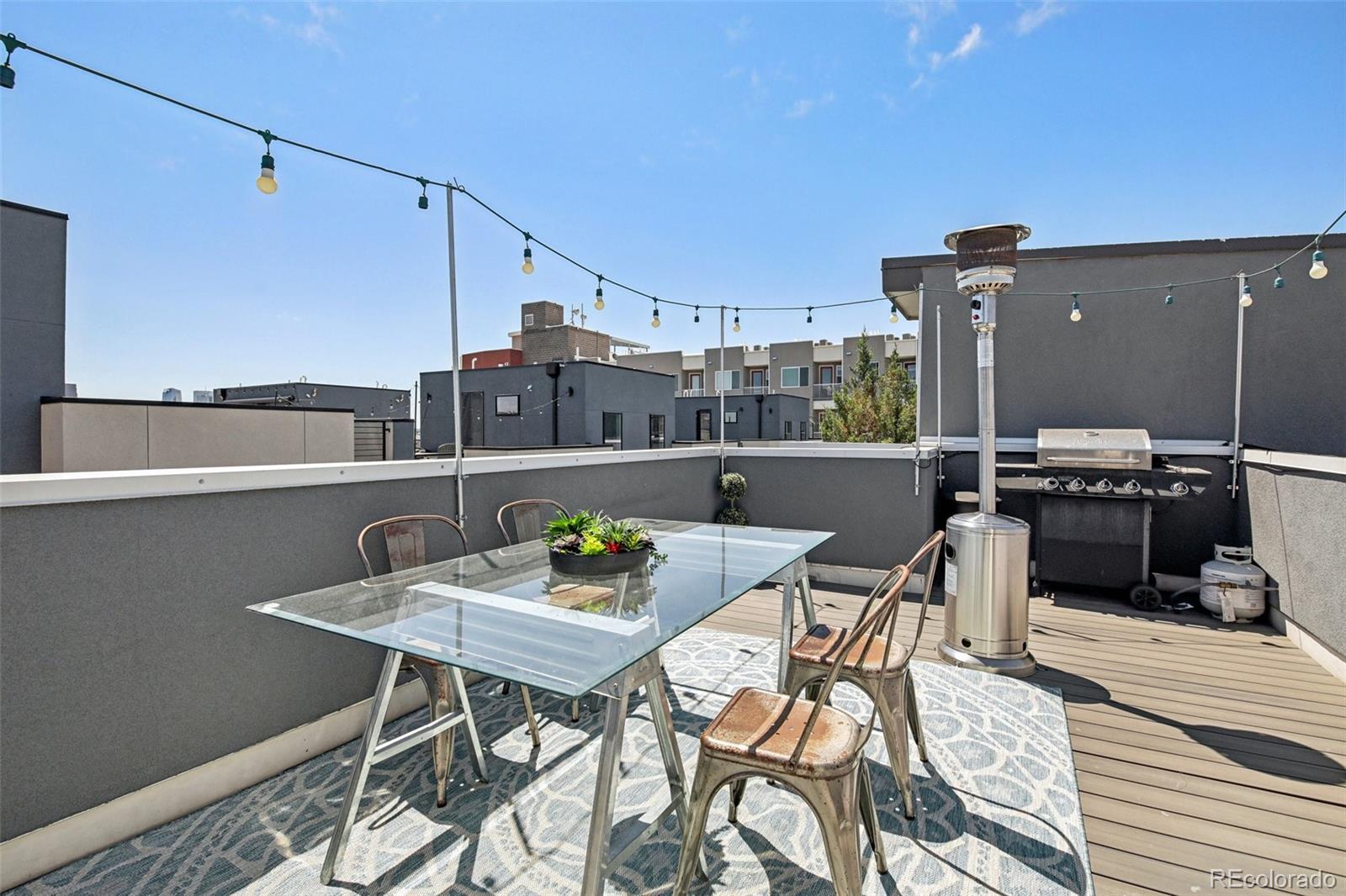 a view of a roof deck with table and chairs