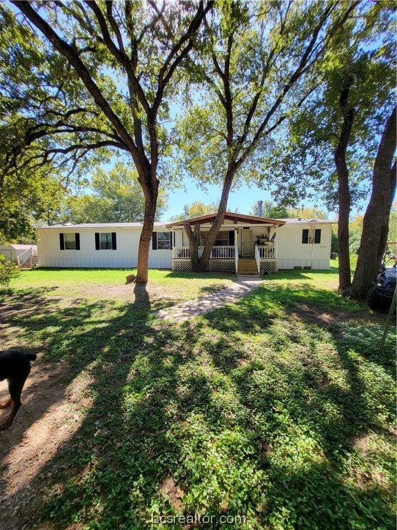 a view of a house with a big yard and large trees