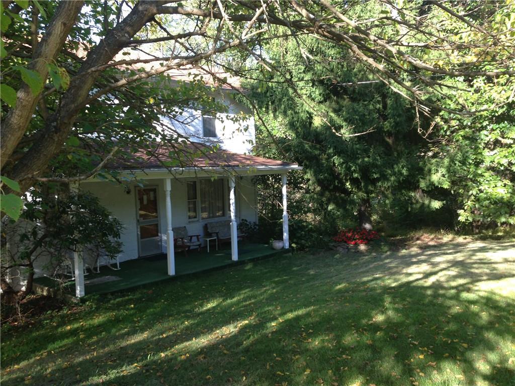 a view of a chair and table in backyard of the house