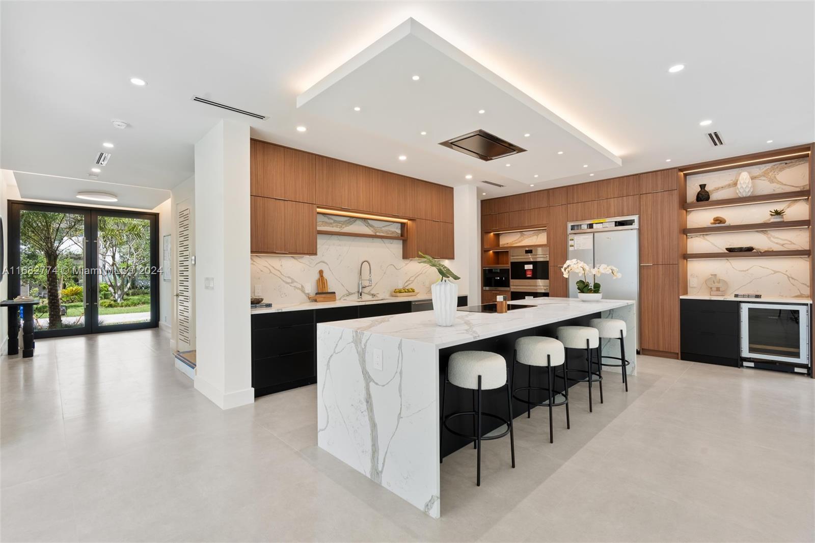 a kitchen with stainless steel appliances kitchen island granite countertop a table chairs sink and cabinets