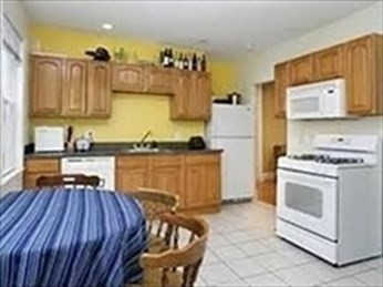 a kitchen with a wooden floor and white appliances