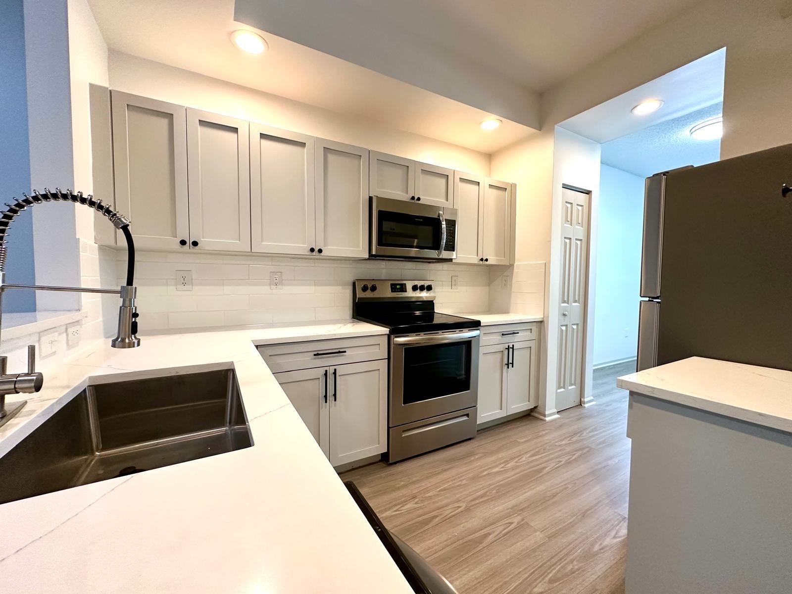 a kitchen with granite countertop a white stove top oven and sink