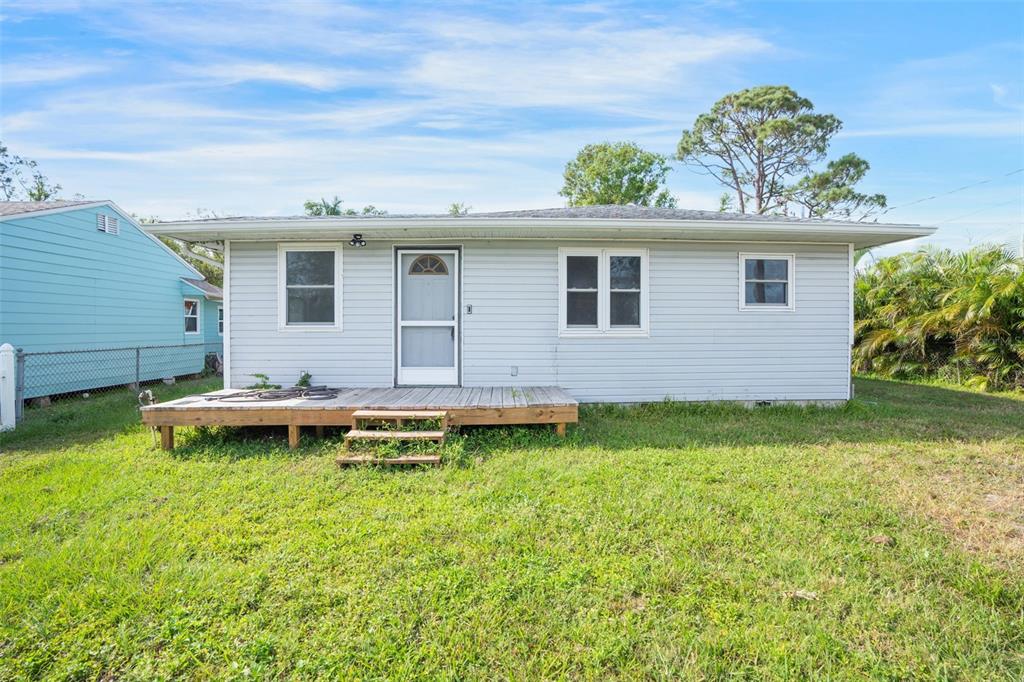 a backyard of a house with table and chairs