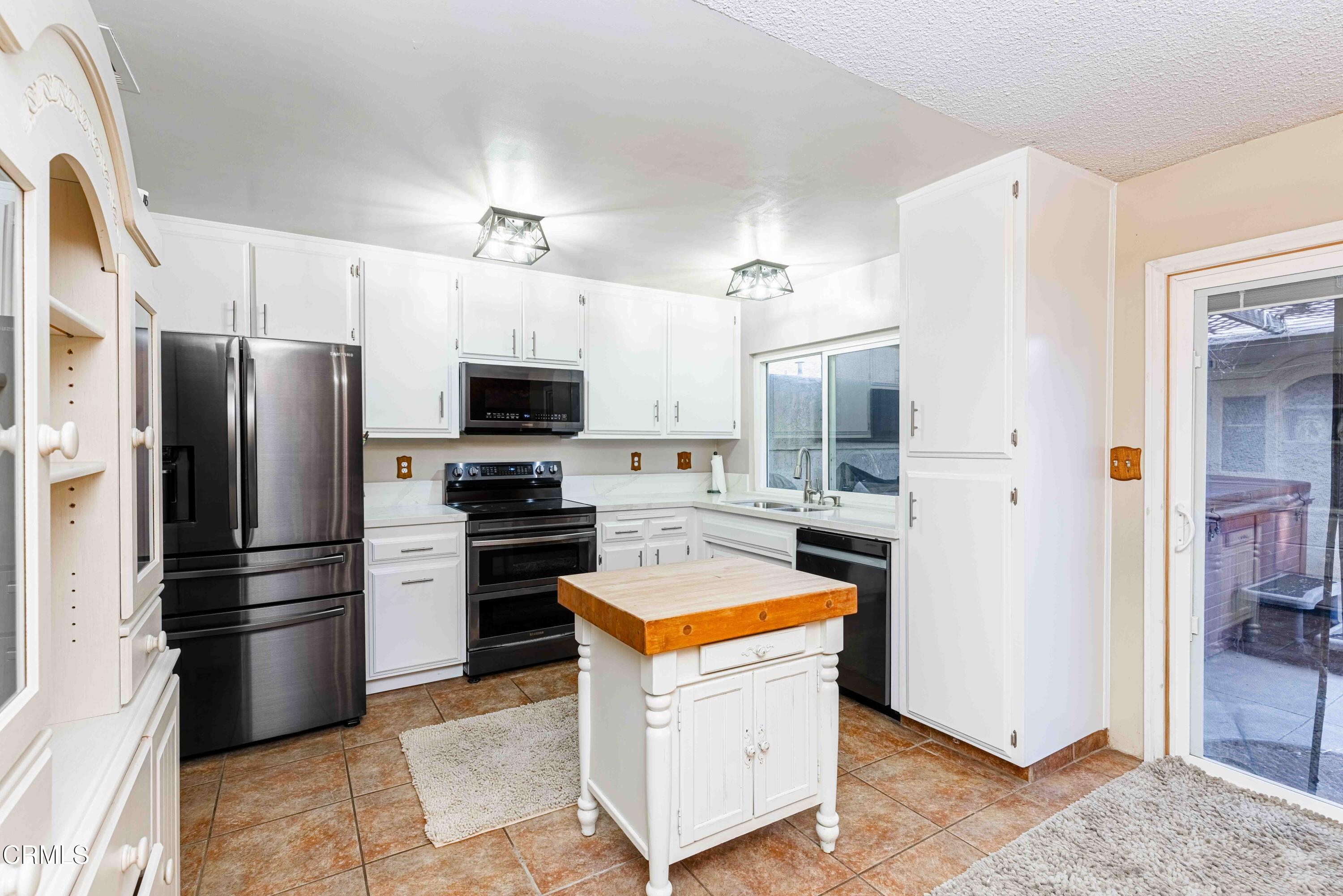 a kitchen with stainless steel appliances a refrigerator stove and microwave