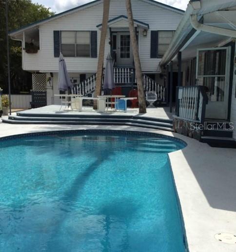 a view of house with swimming pool yard and outdoor seating