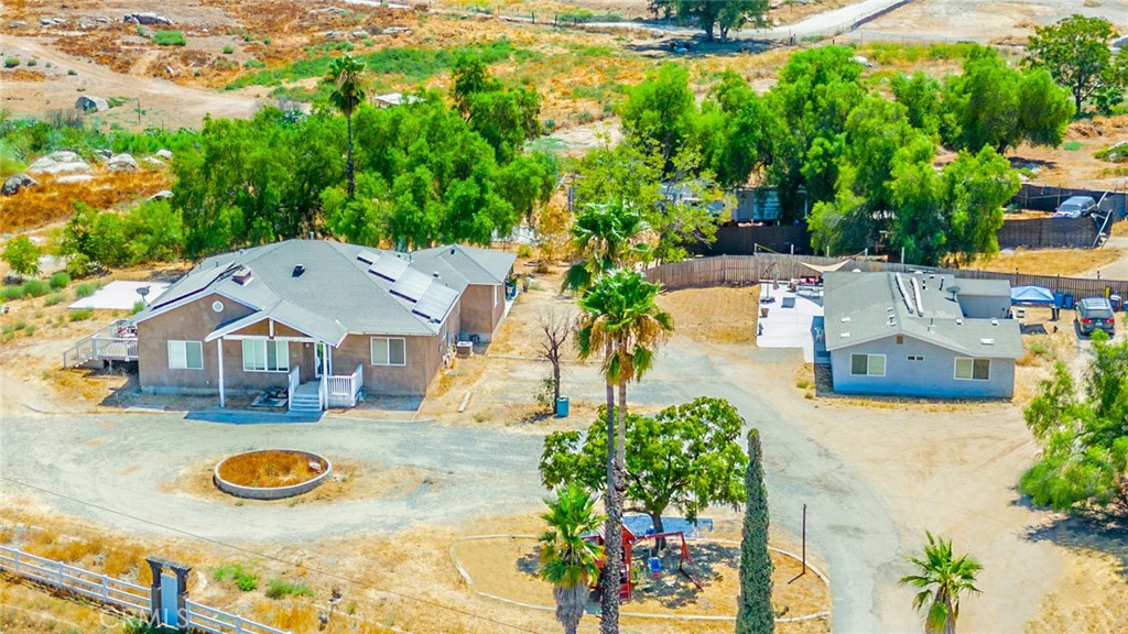 an aerial view of a house with yard and swimming pool