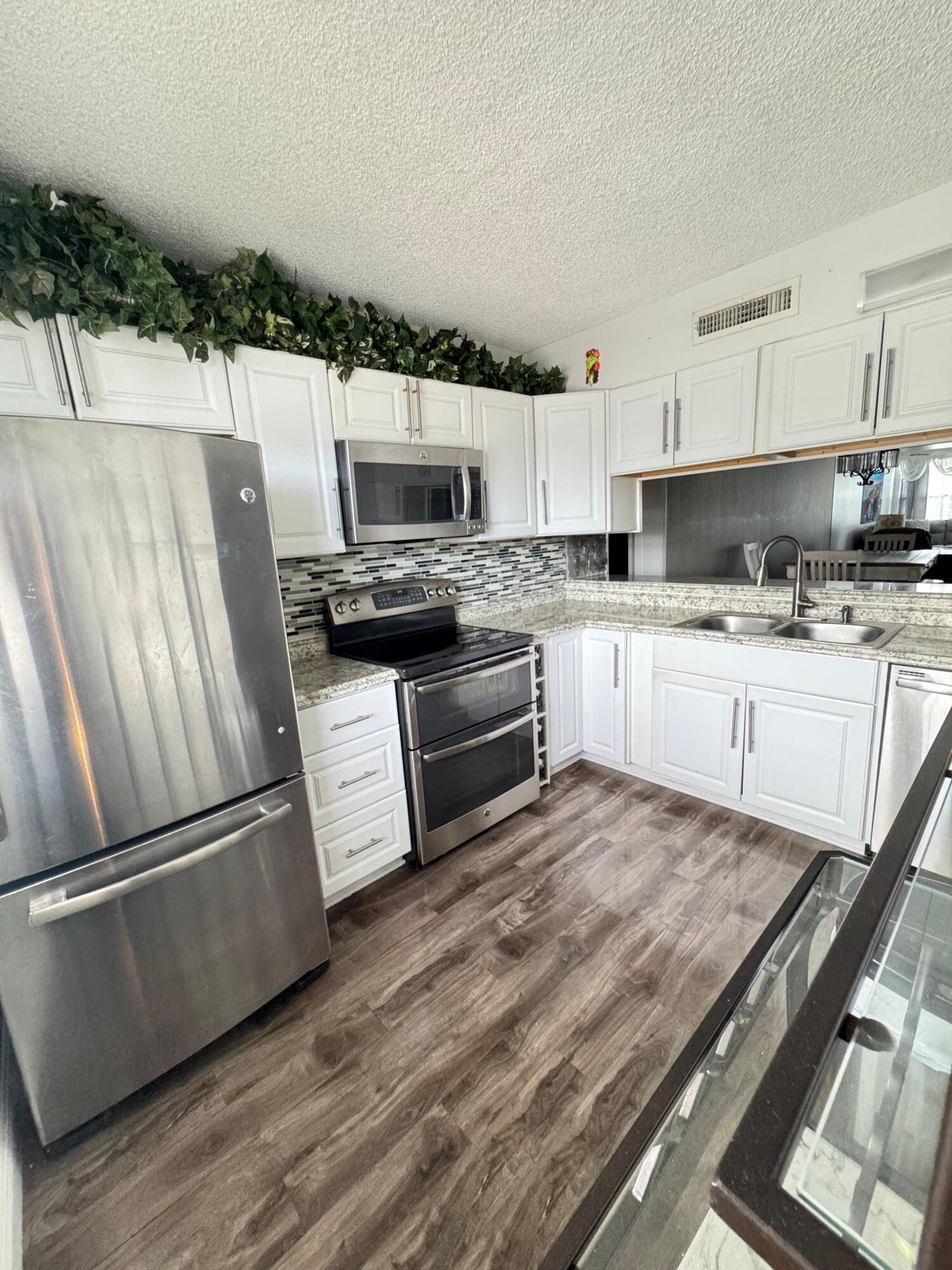 a kitchen with stainless steel appliances a stove a sink and a refrigerator