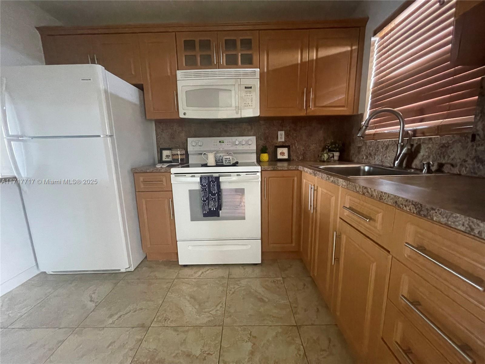 a kitchen with a refrigerator sink stove and cabinets