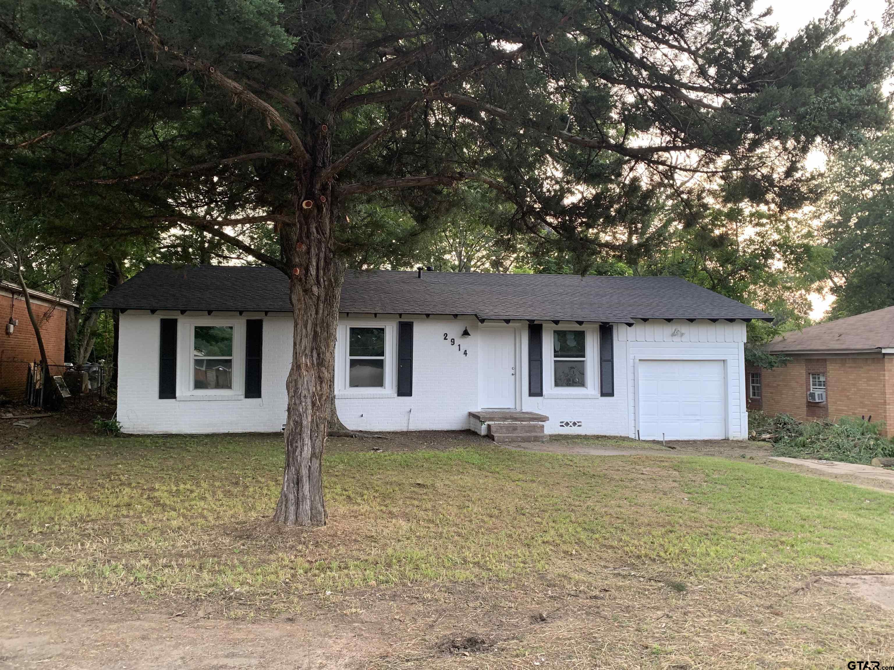 a house that has a tree in front of the house