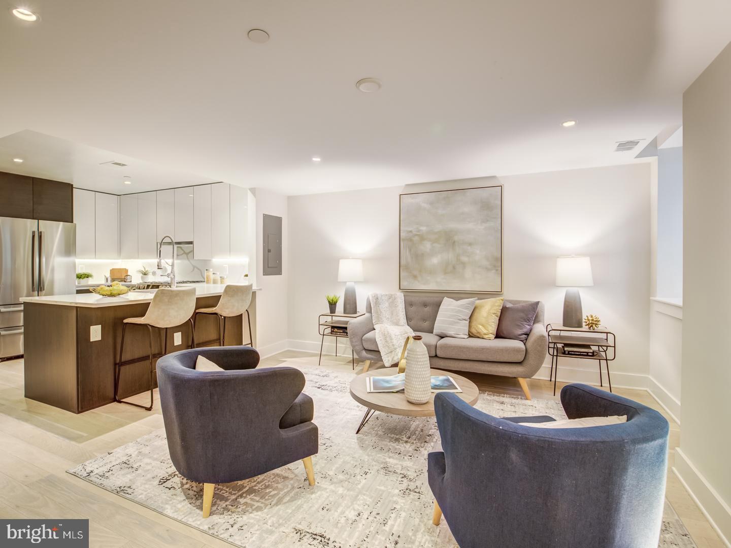 a living room with furniture and a view of kitchen