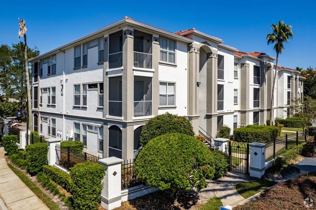 a front view of a building with balcony and garden