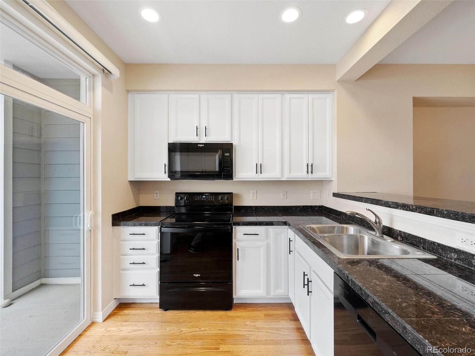 a kitchen with granite countertop a sink and a stove top oven