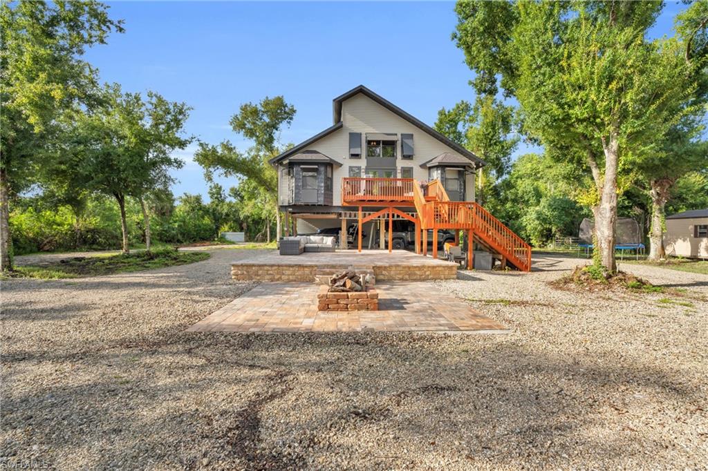 Rear view of house with an outdoor fire pit, a wooden deck, and a patio