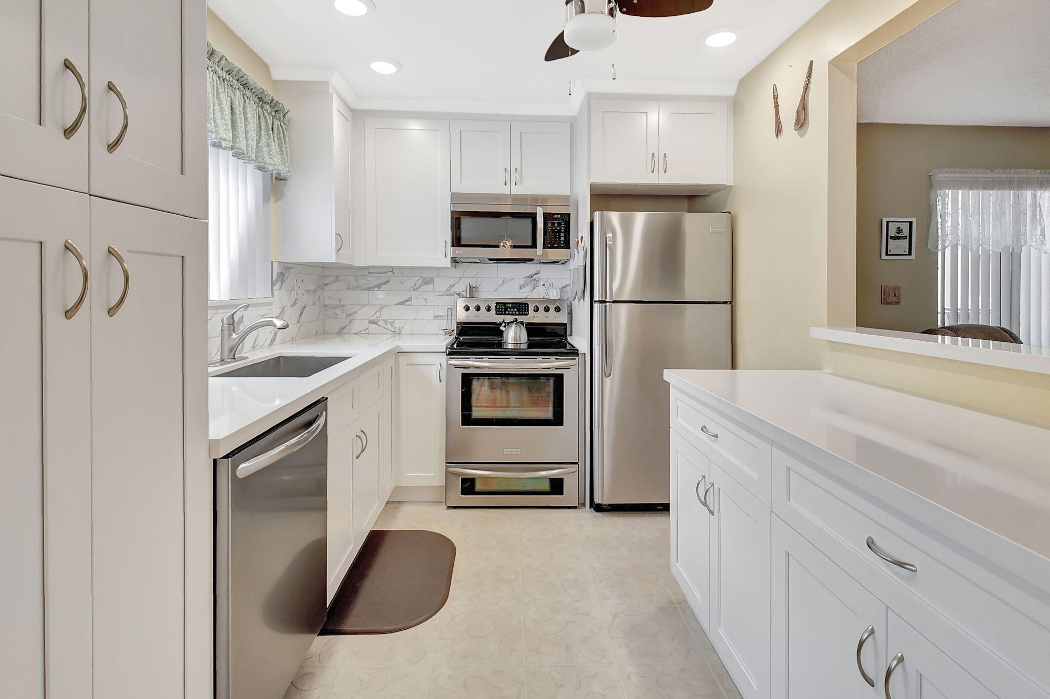 a kitchen with stainless steel appliances kitchen island a refrigerator sink and cabinets