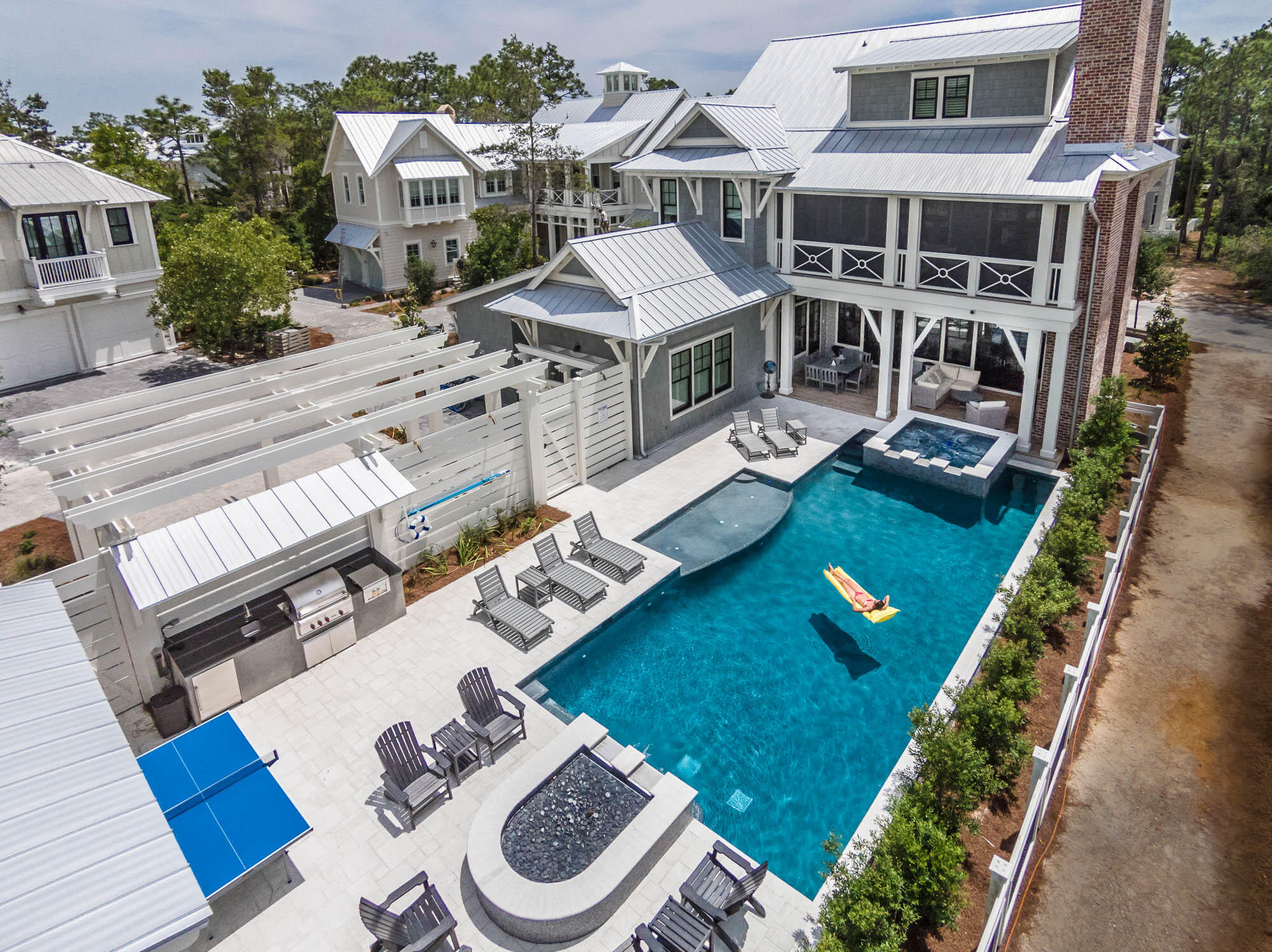 a view of a house with backyard sitting area and swimming pool