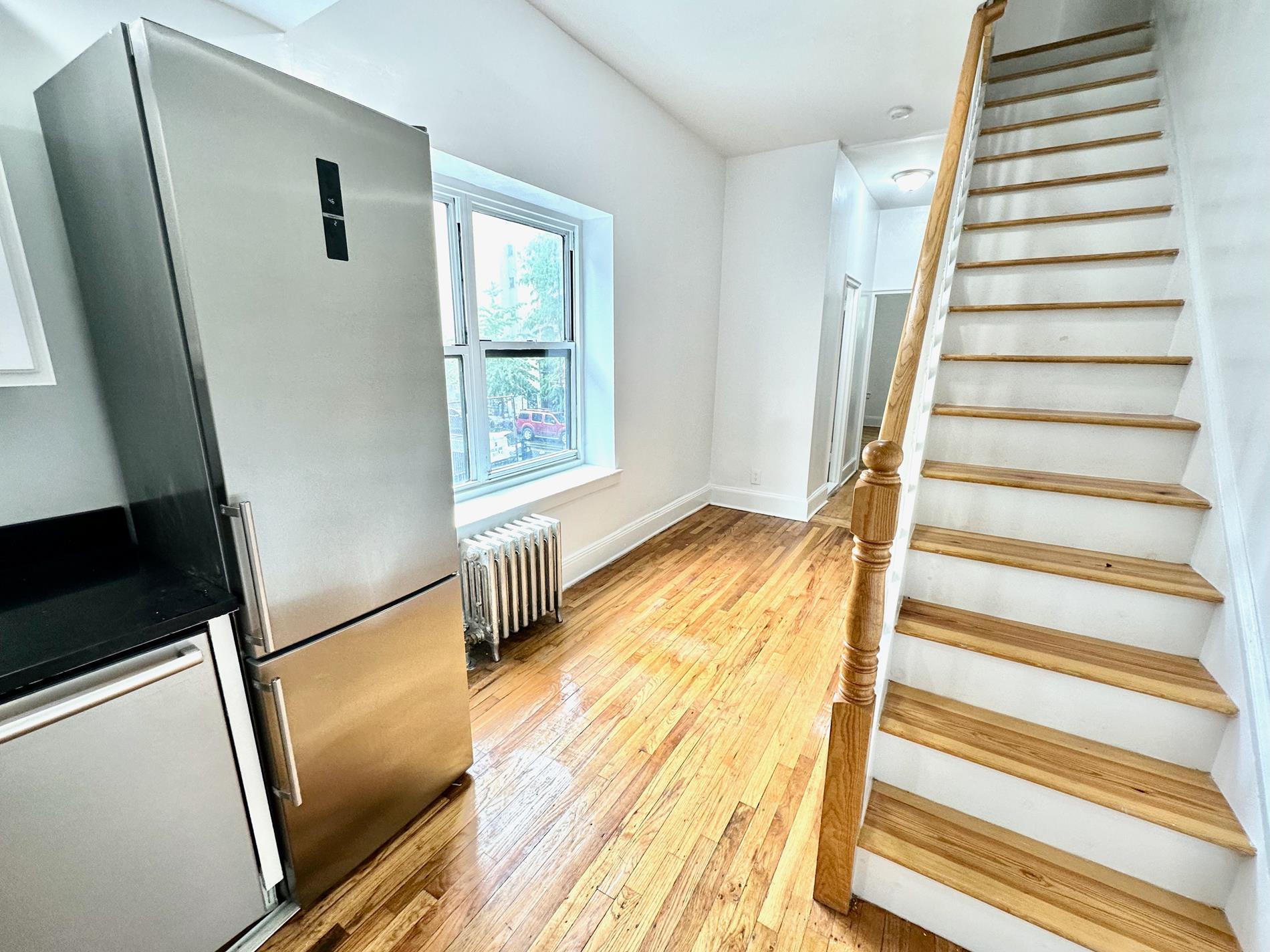 a view of an entryway with wooden floor and door