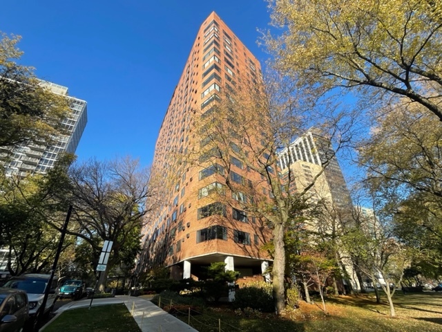 a view of a tall building next to a road