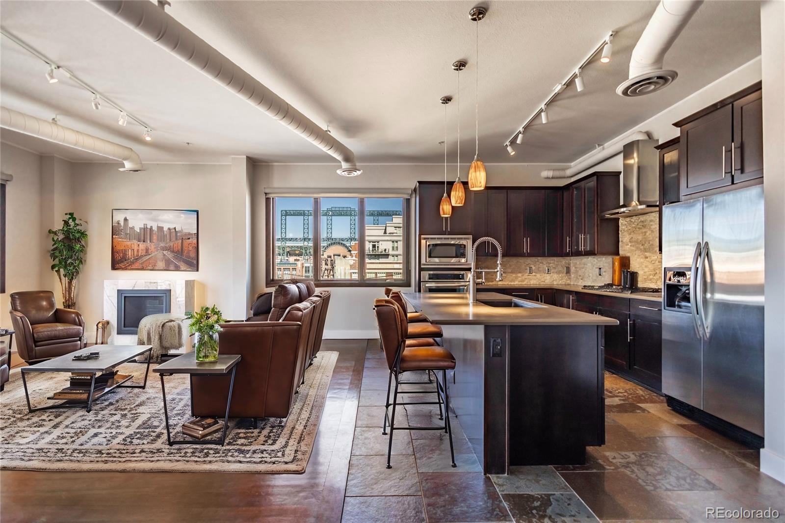 a dining hall with stainless steel appliances granite countertop a stove and a living room view