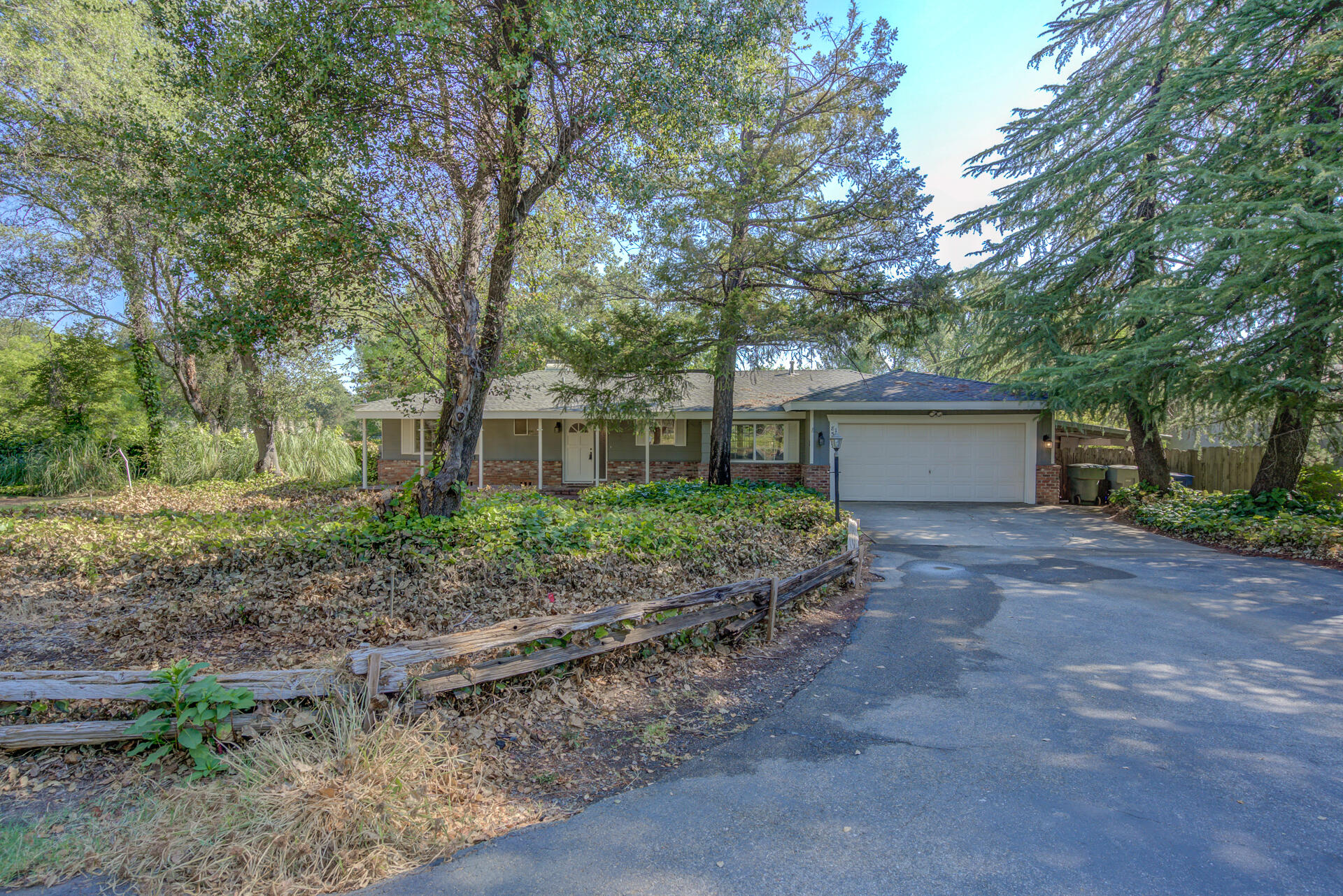 a front view of a house with a garden and trees