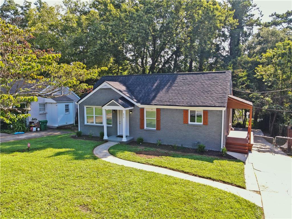 a front view of a house with a yard and trees