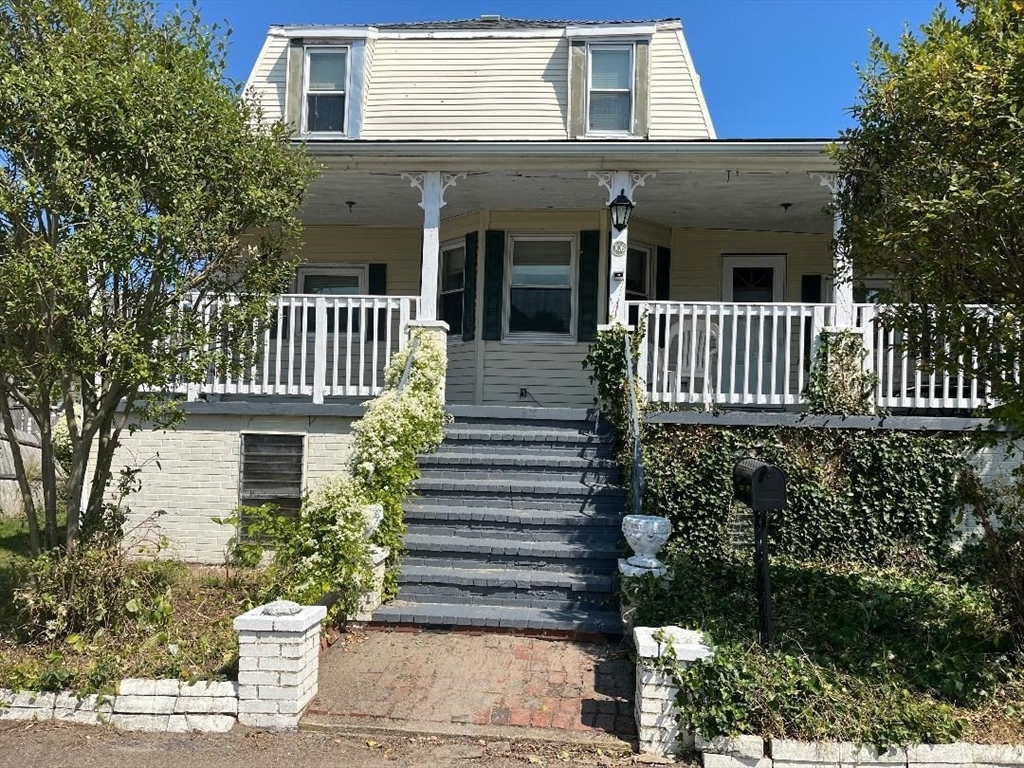 a view of a house with a small yard and flower plants